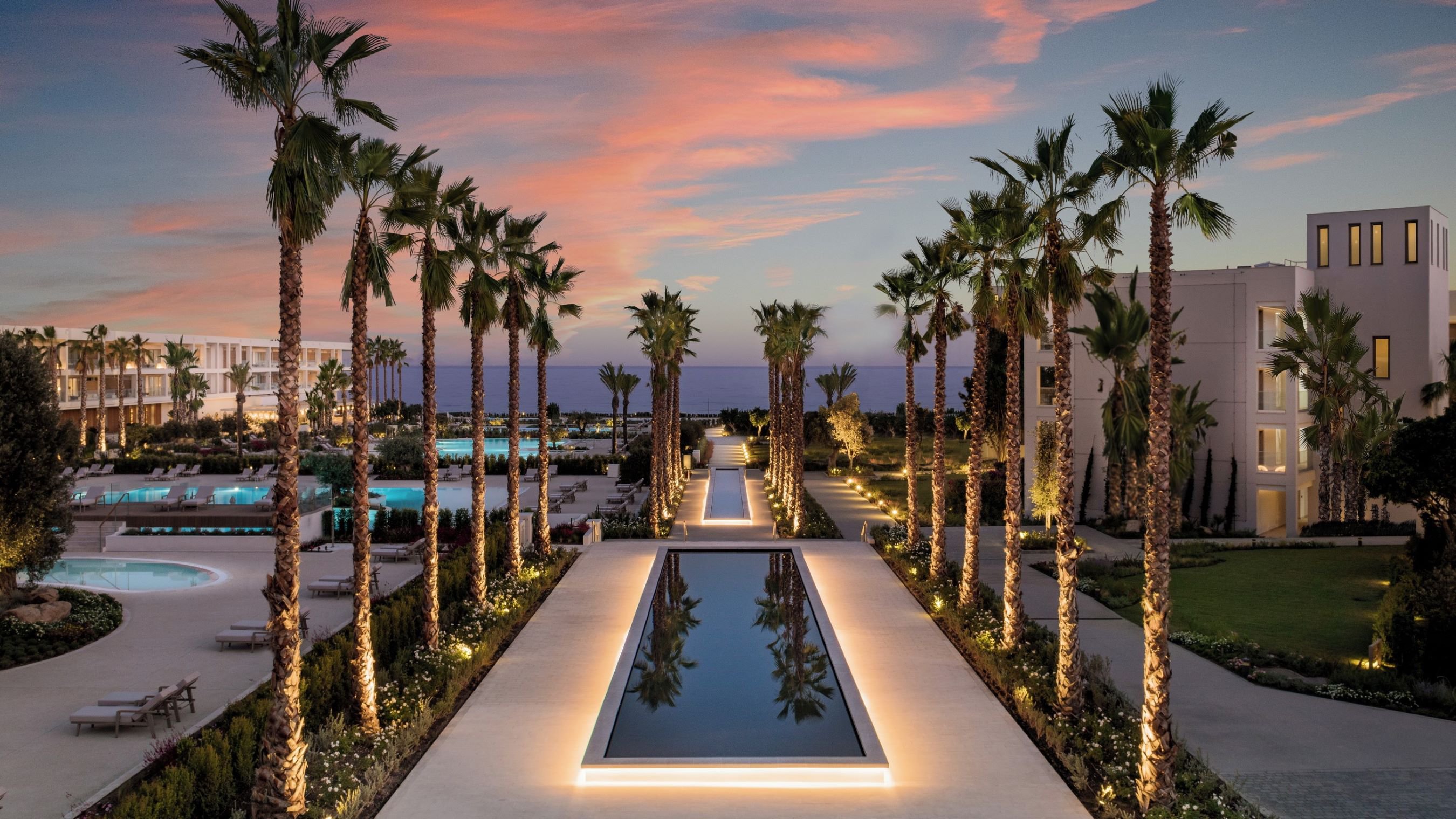 Blick auf die elegante Hotelanlage Ikos Andalusia mit mehreren Swimmingpools, umgeben von Palmen und gepflegten Gärten | © Ikos Andalusia