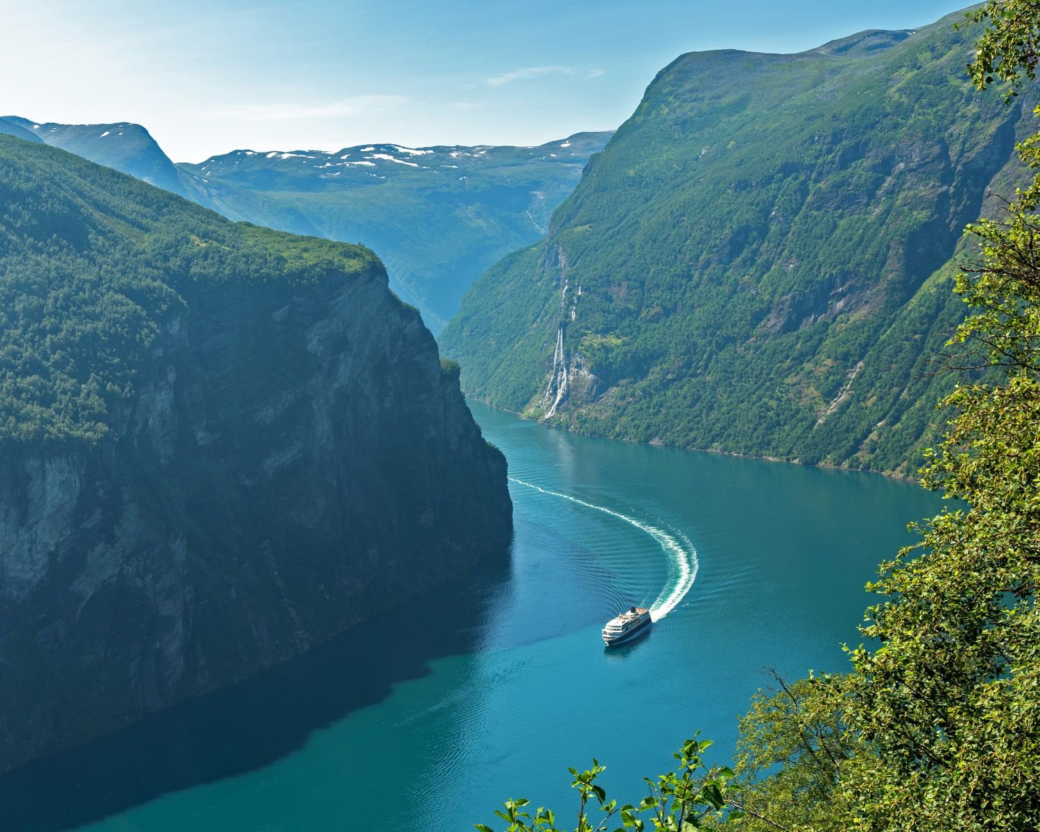 Blick auf den Geirangerfjord in Norwegen mit steilen Bergen, Fjordlandschaft und einem Kreuzfahrtschiff auf dem Wasser | © Getty Images