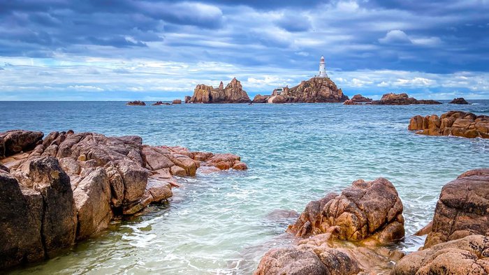 Der Corbière Lighthouse an der Küste von St. Ouen auf Jersey an einem bewölkten Septembertag, umgeben von Felsen und dem Meer | © Getty Images
