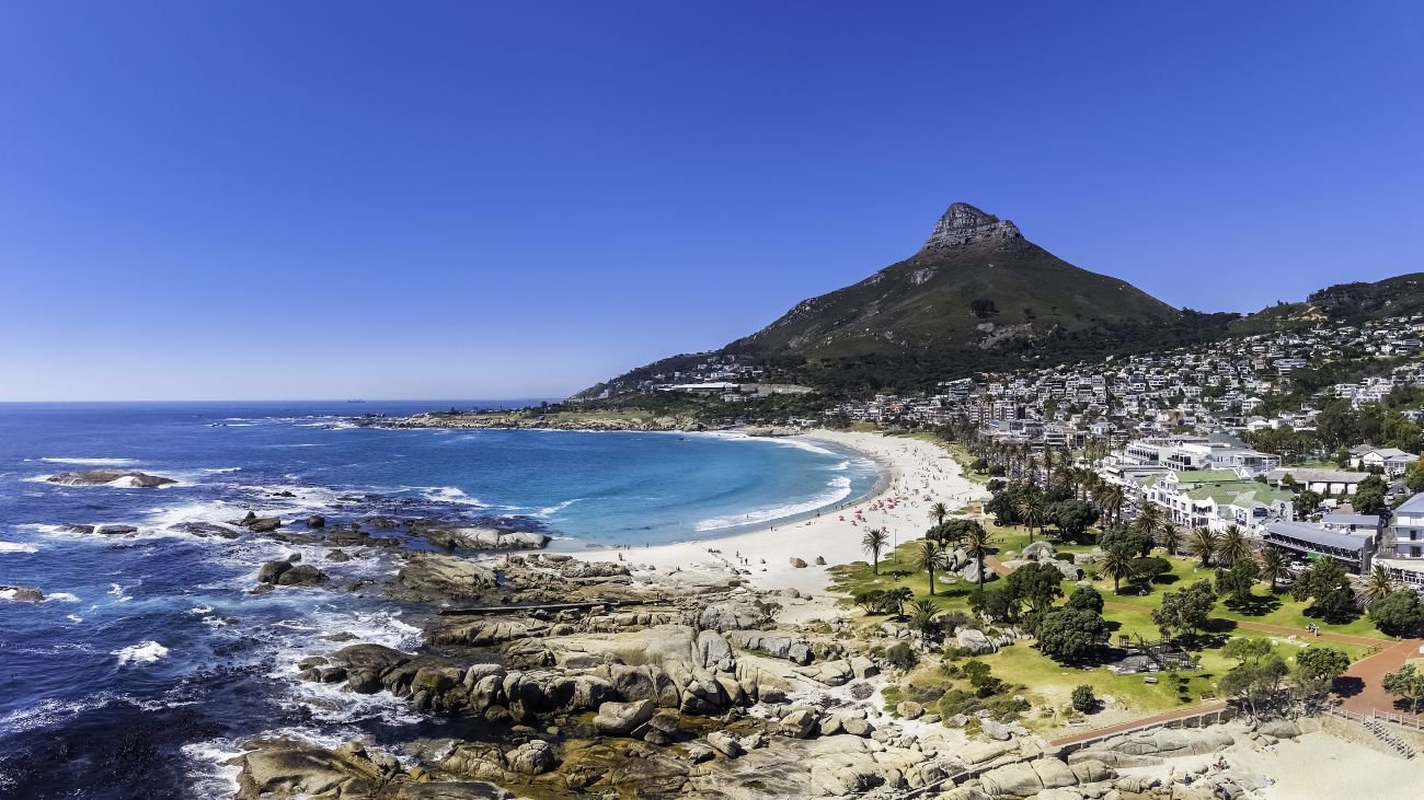 Blick auf Camps Bay mit Strand, felsiger Küste sowie Restaurants und Bars in Kapstadt | © Getty Images