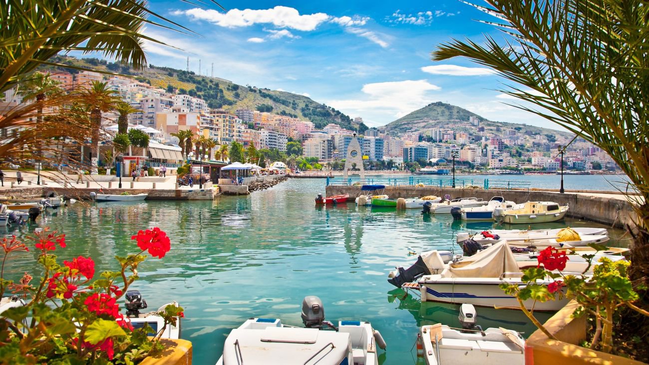 Blick auf den Hafen von Saranda am Ionischen Meer, mit Booten im Wasser, Küstengebäuden und der mediterranen Landschaft im Hintergrund | © Getty Images