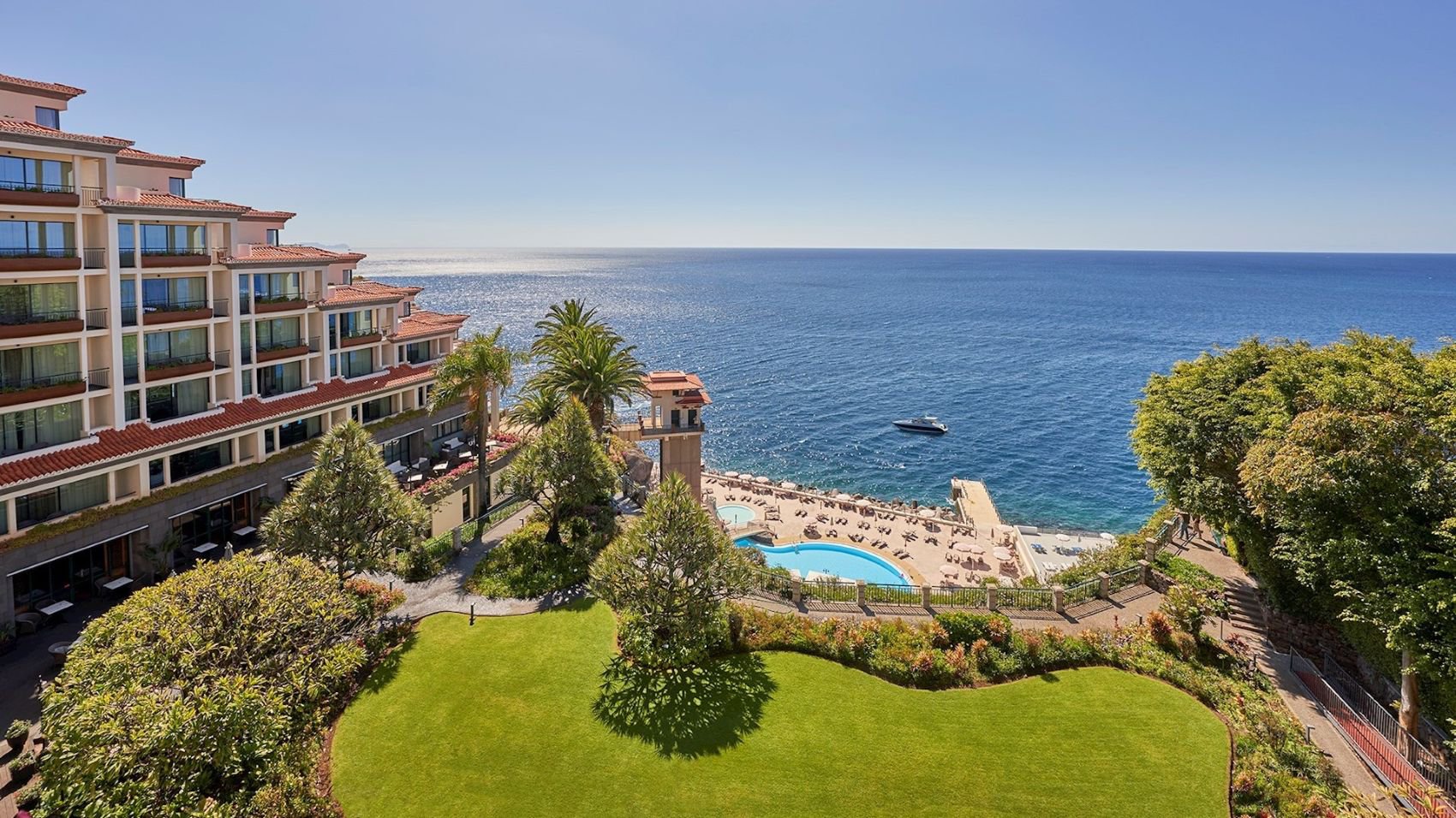 Außenansicht des The Cliff Bay mit Hotelgebäude, Gartenanlage und Klippenlage über dem Meer | © The Cliff Bay