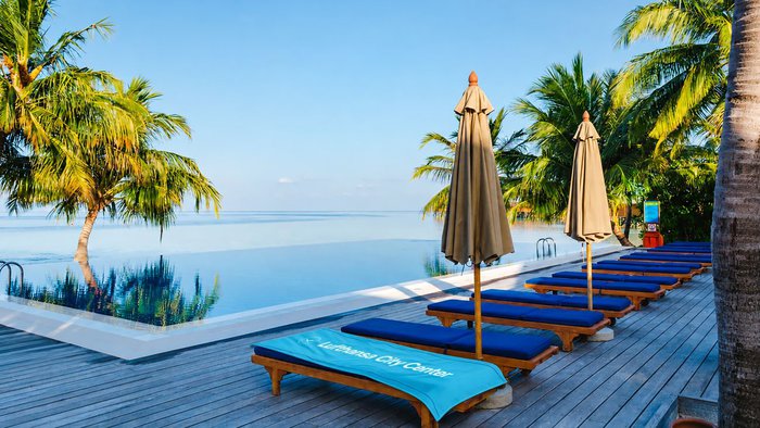 Poolbereich mit komfortablen Liegen und Blick auf das Meer | © Lufthansa City Center