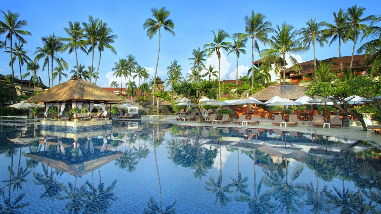 Der große, elegante Hauptpool des Nusa Dua Beach Hotel & Spa, umgeben von Palmen und Gartenanlagen | © Nusa Dua Beach Hotel & Spa