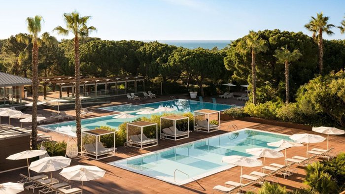Poolbereich mit Liegen und Daybeds im EPIC SANA Algarve, umgeben von mediterraner Gartenlandschaft | © EPIC SANA Algarve