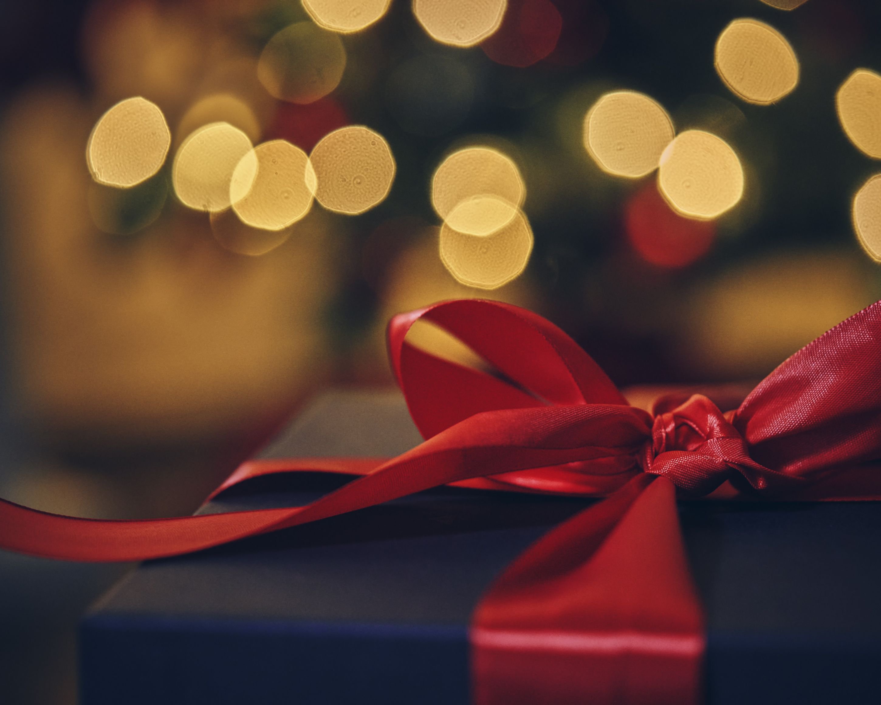 Weihnachtsgeschenk in festlicher, warmer Atmosphäre | © Getty Images