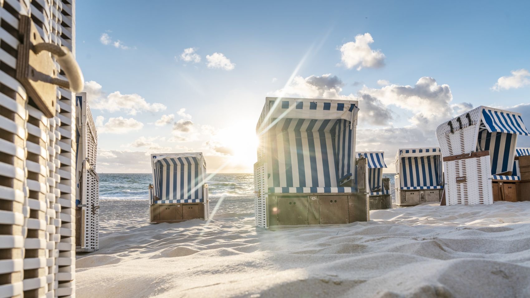 Typische Strandkörbe am breiten Sandstrand von List auf Sylt vor dem Meer | © Getty Images