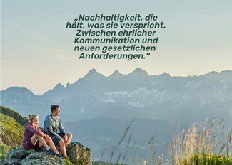 Zwei Wanderer genießen den Ausblick auf die beeindruckende Berglandschaft