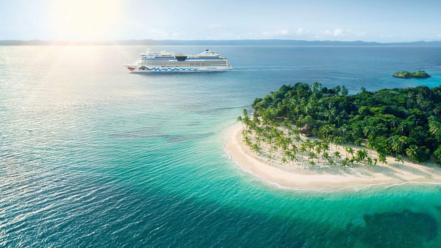 AIDAdiva vor einer kleinen, möglicherweise tropischen Insel; im Hintergrund ist das Festland zu sehen | © AIDA Cruises