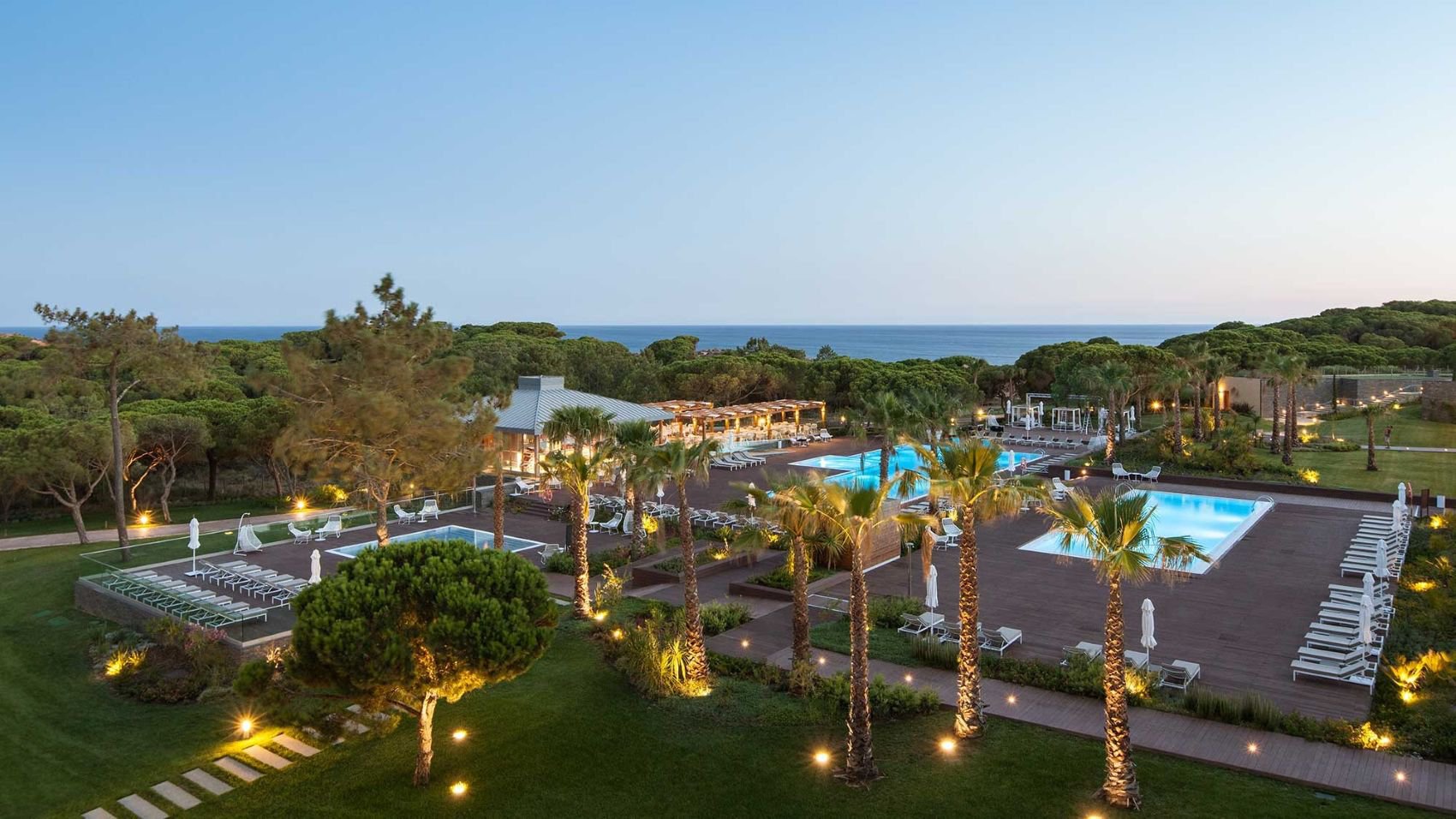 Poolbereich des EPIC SANA Algarve in der stimmungsvollen Abenddämmerung mit sanfter Beleuchtung | © EPIC SANA Algarve