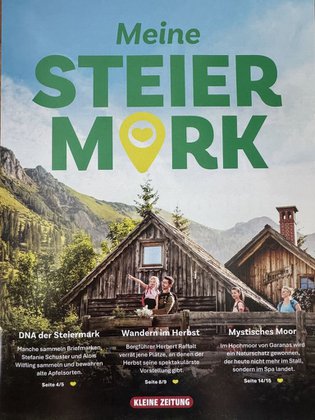 Titelseite des Magazins von der Herbstausgabe Meine Steiermark. Im Hintergrund sieht man felsige Berge, einen blauen Himmel mit ein paar Wolken. Im Vordergrund sieht man zwei Hütten mit einer Familie, welche sich umsieht. Auf dem Magazin steht in grüner Schrift Meine Steiermark und die wichtigsten Untertitel vom Magazin. 
