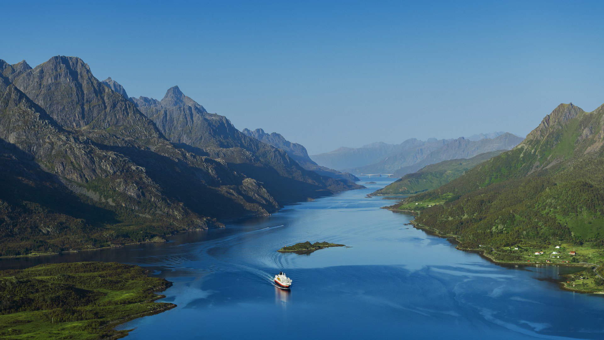 Blick auf den Raftsundet mit einem Hurtigruten-Kreuzfahrtschiff, das durch die enge Meeresstraße zwischen steilen Bergen fährt, über tiefblauem Wasser | © Stian Klo