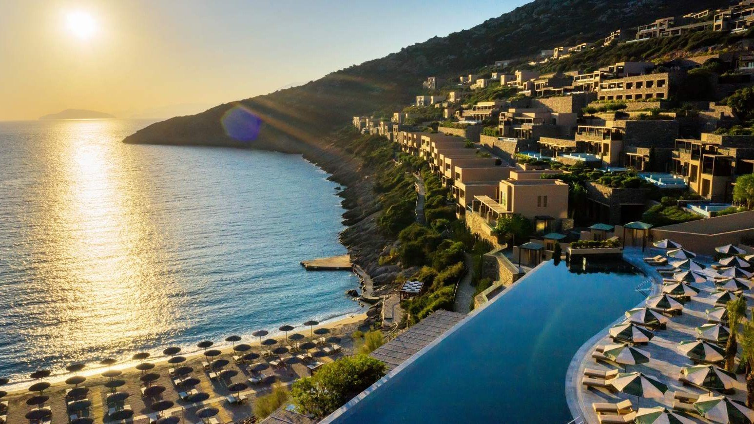 Das Daios Cove in der Abendsonne mit Blick auf den Infinity-Pool, den Strand und das Meer | © Daios Cove