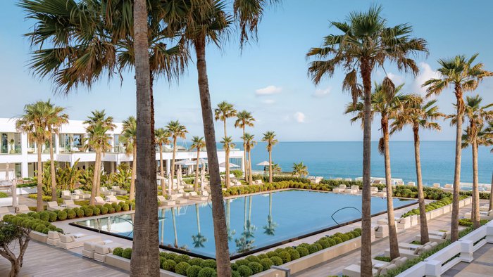 Stilvoller Poolbereich des Grecotel LUX®ME White mit traumhaftem Blick auf das Meer und eleganter Atmosphäre | © Grecotel Hotels & Resorts