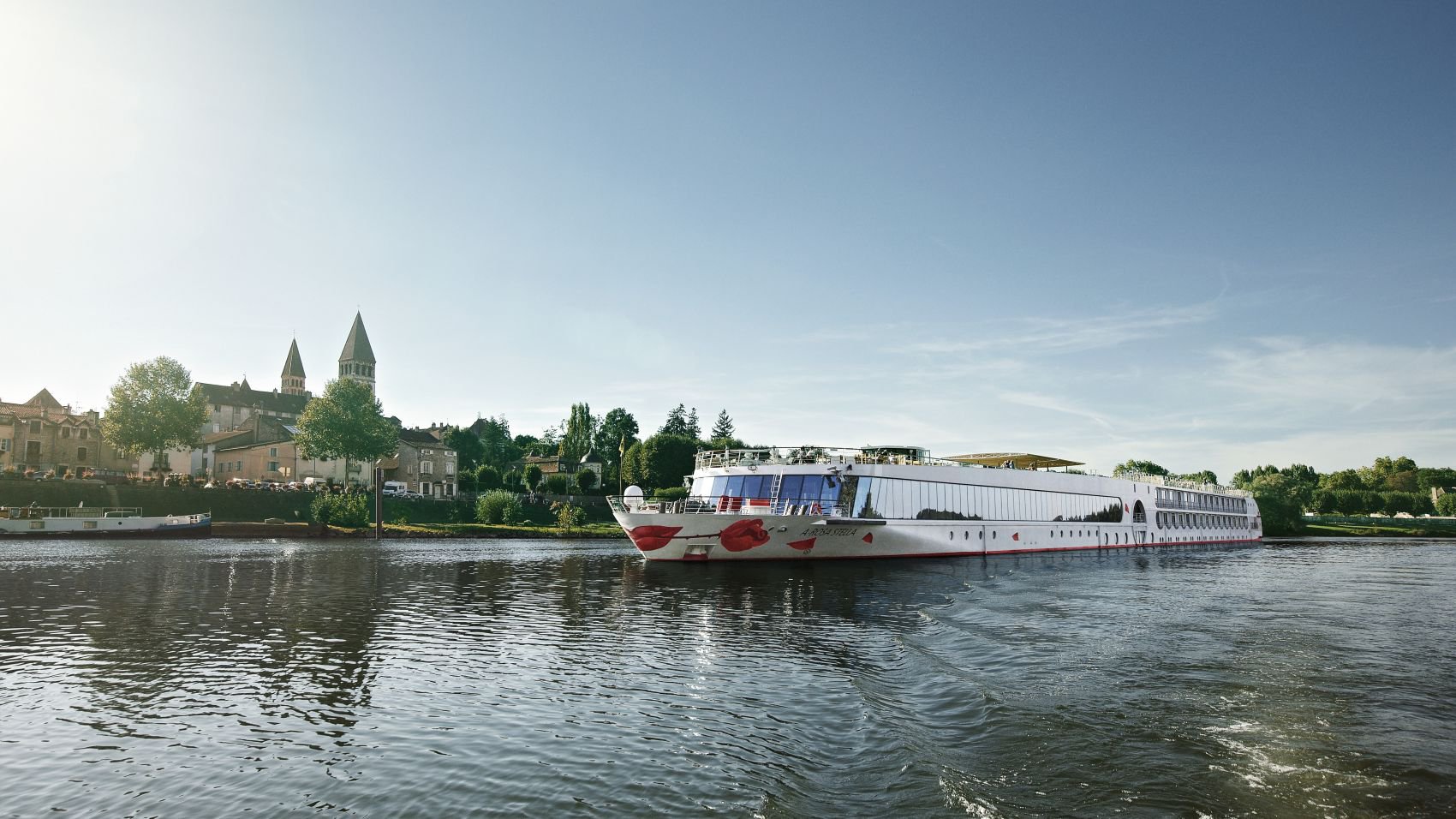 Die A-ROSA Stella fährt auf einem Fluss an einem idyllischen kleinen Ort vorbei | © A-ROSA