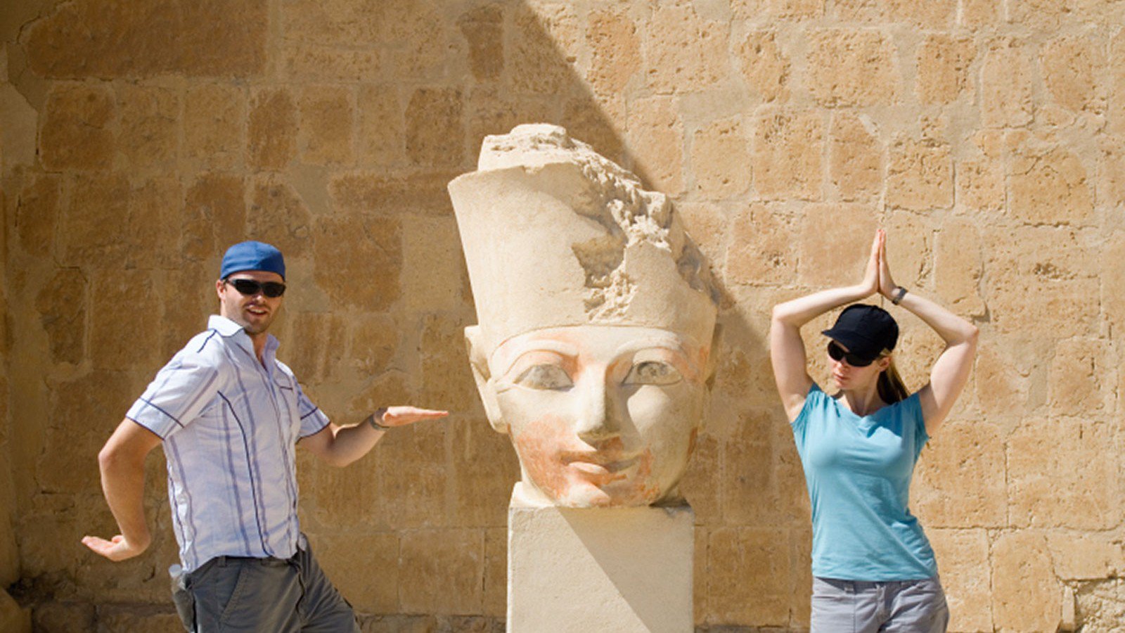 Zwei Touristen haben Spaß vor einer Statue in Ägypten | © Studiosus