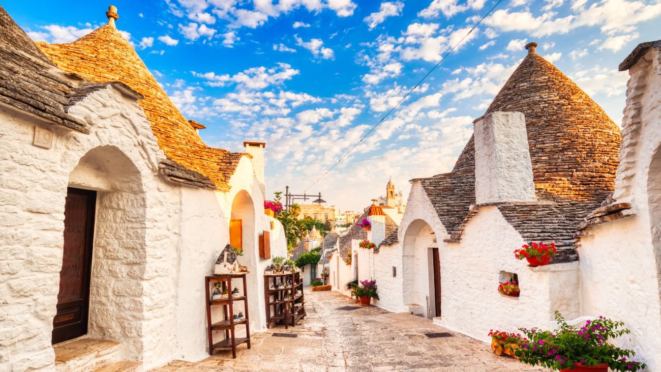 Berühmte Trulli Häuser während eines sonnigen Tages mit strahlend blauem Himmel in Alberobello, Apulien, Italien | © Getty Images