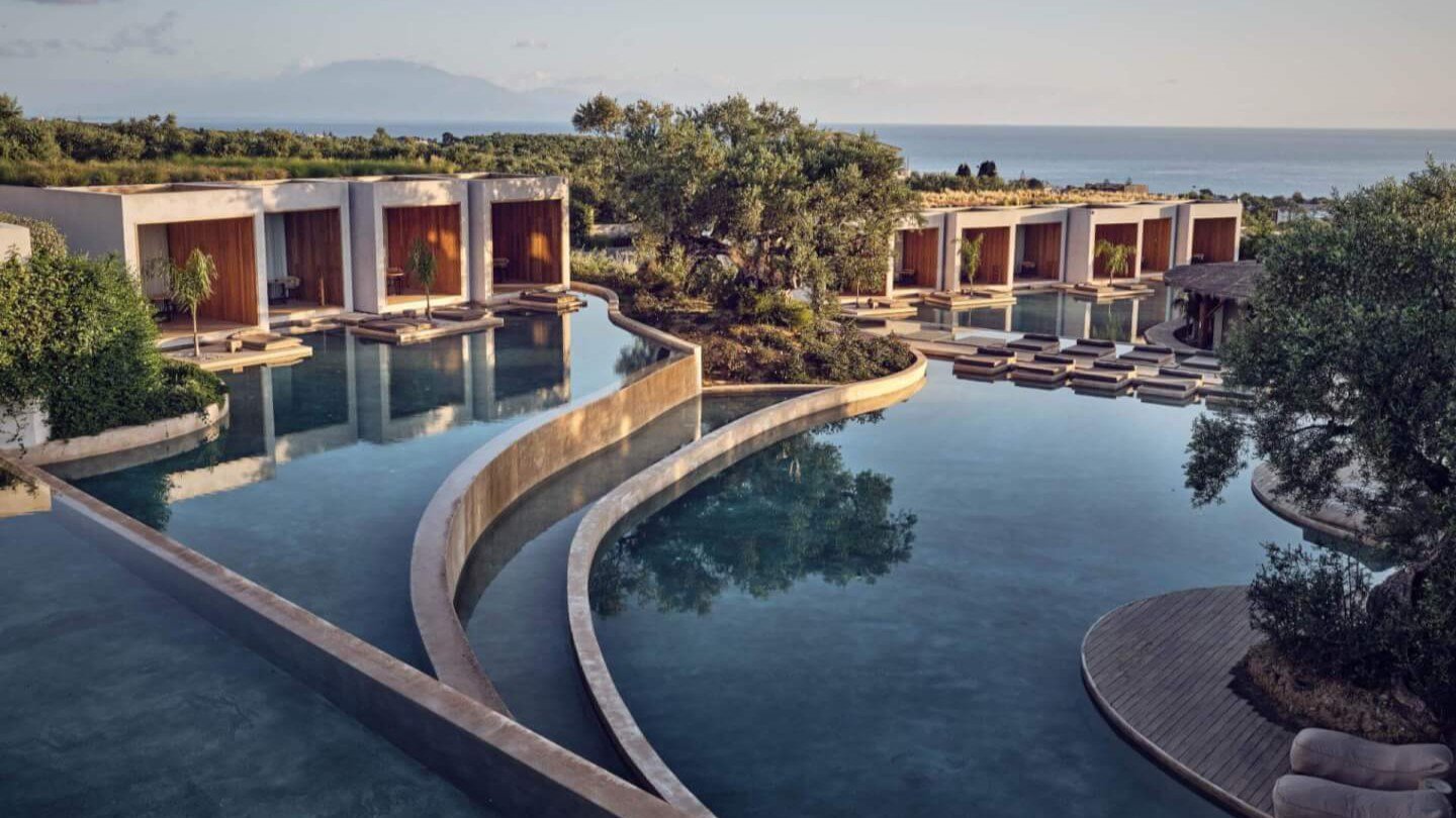 Poolbereich auf mehreren Ebenen mit Hotelgebäuden, Suiten mit direktem Poolzugang und Meer im Hintergrund im Olea All Suite Hotel | © Olea All Suite Hotel