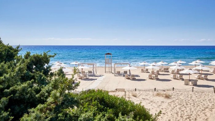 Feinsandiger Strand am Baia di Chia Resort Sardinia, Curio Collection by Hilton, mit türkisblauem Meer an der Küste Sardiniens | © Baia di Chia Resort Sardinia, Curio Collection by Hilton