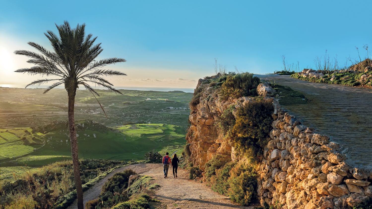 Wanderer genießen eine idyllische Szenerie auf Gozo, umgeben von sanften Hügeln und mediterraner Landschaft | © VisitMalta
