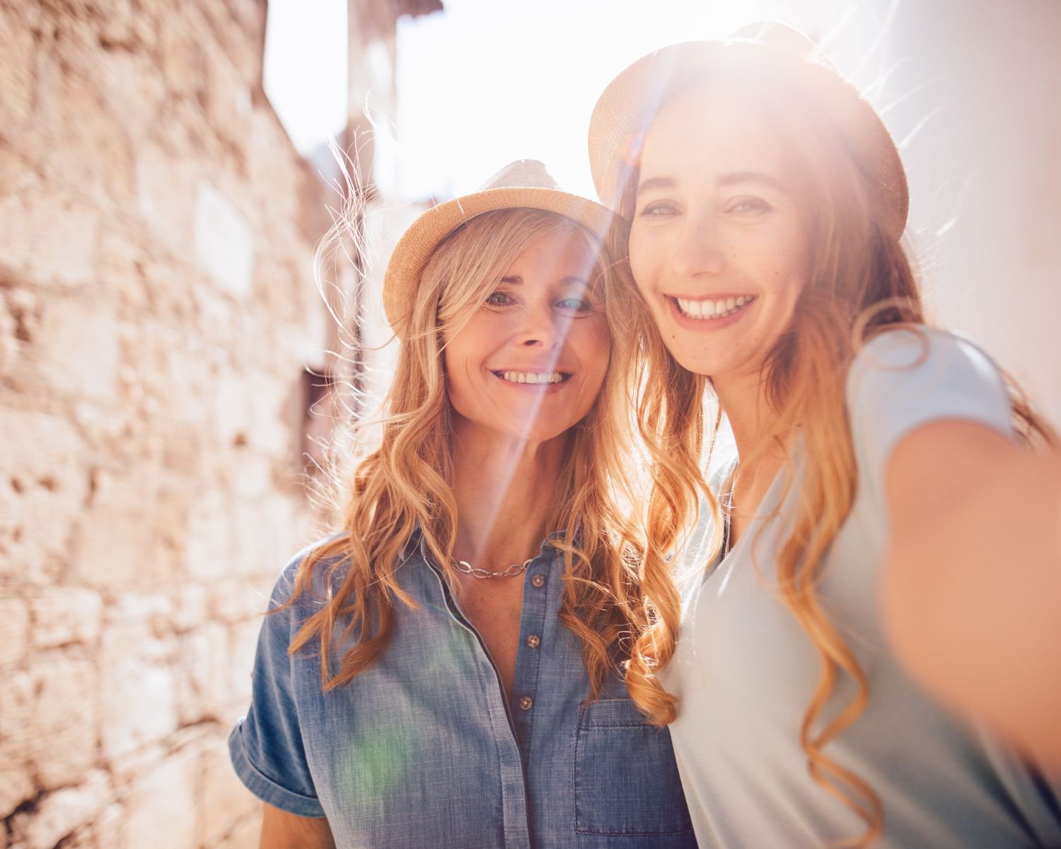 Lächelnde Mutter und erwachsene Tochter machen gemeinsam ein Selfie auf einer Reise in Europa | © Getty Images