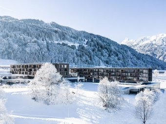 Außenansicht des Falkensteiner Family Hotel Montafon im Winter, umgeben von verschneiten Bergen und winterlicher Alpenlandschaft | © Falkensteiner Family Hotel Montafon