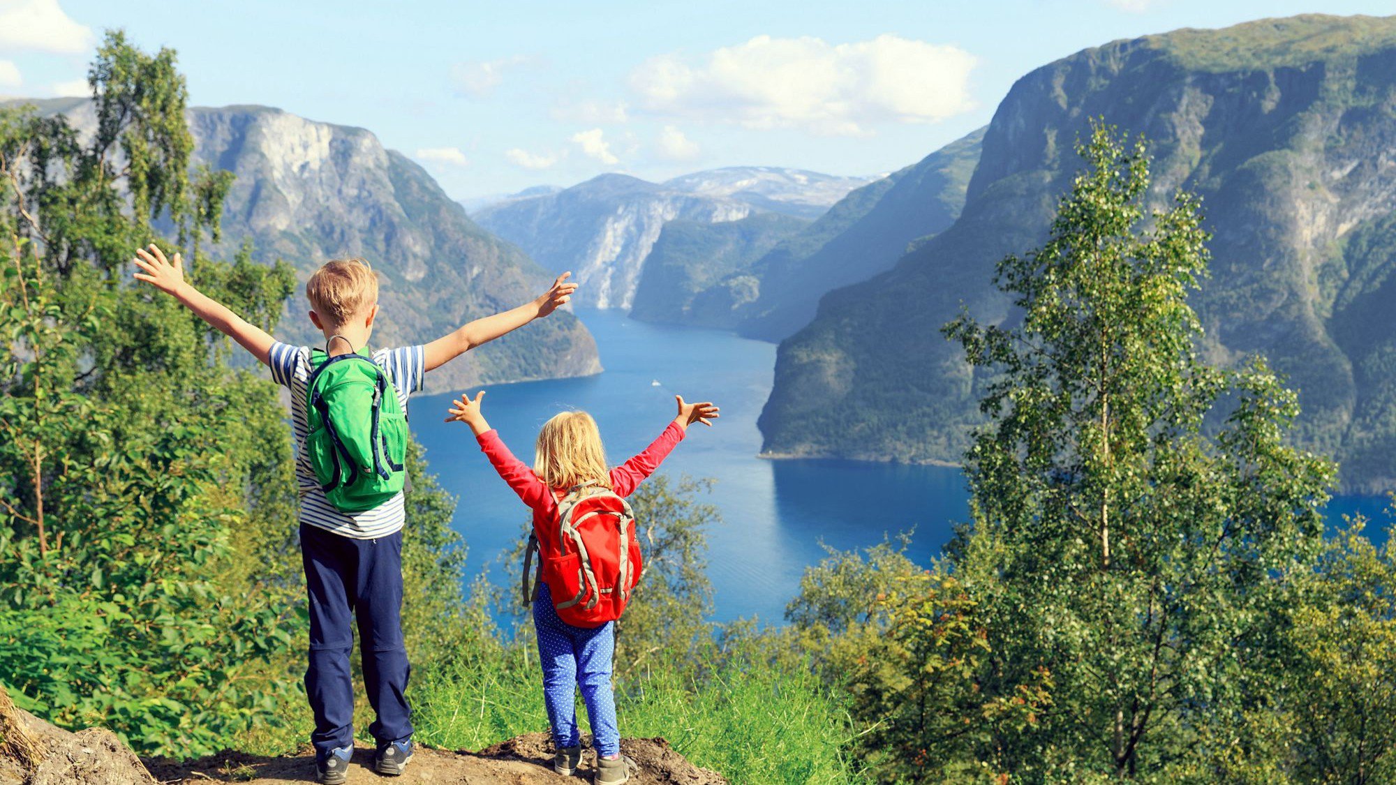 Kinder genießen die Aussicht und stehen glücklich an einem Fjord in Norwegen | © AIDA
