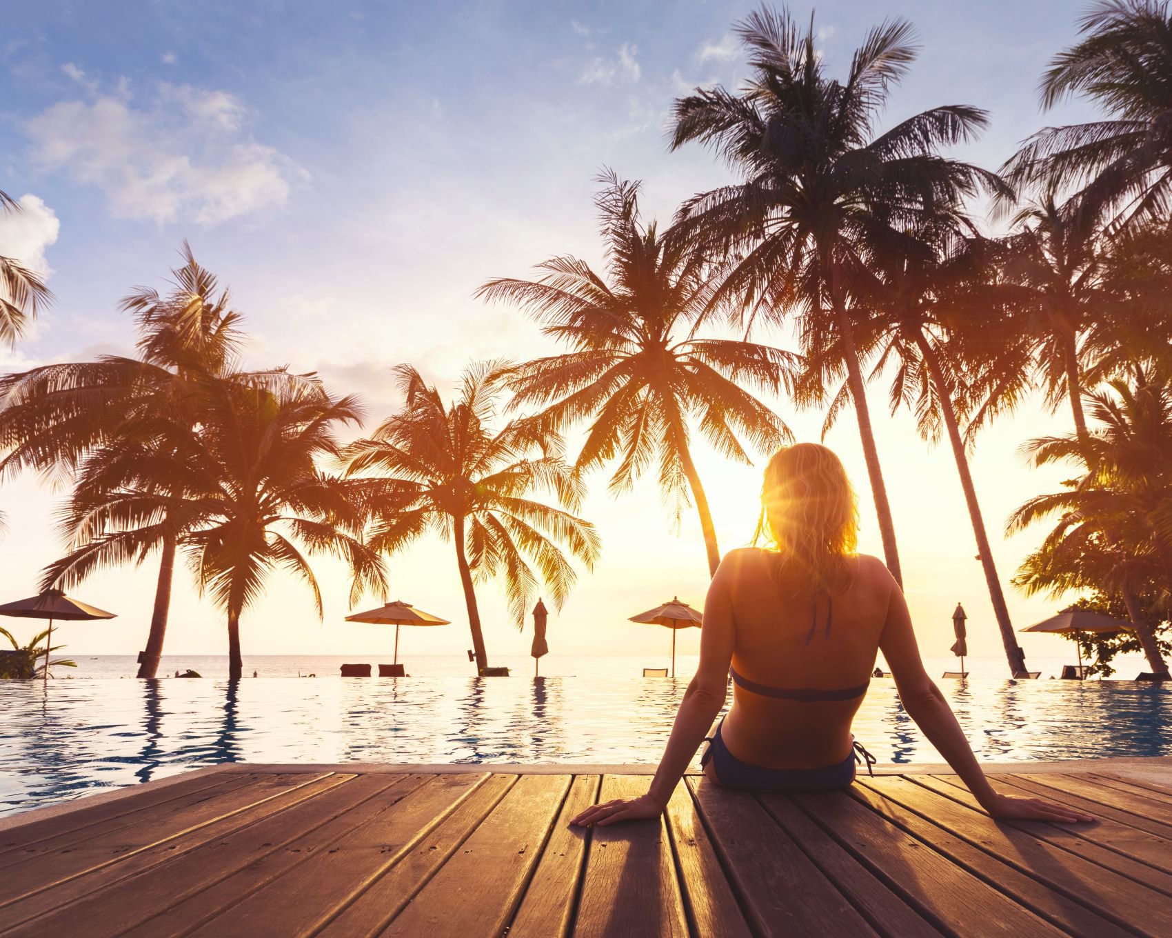 Frau genießt ihren Urlaub am Pool eines luxuriösen Strandhotels | © Getty Images