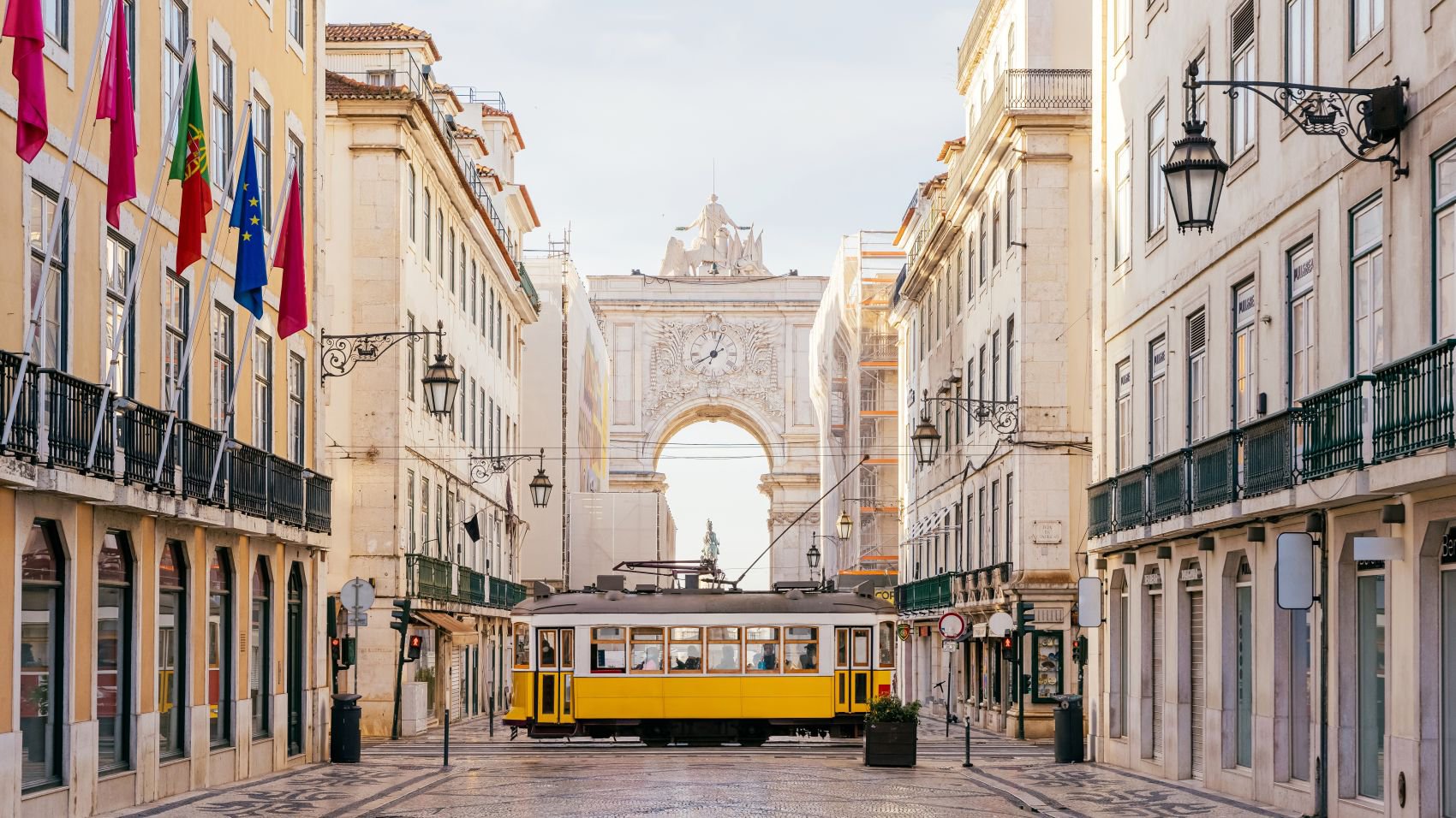 Blick auf den Arco da Rua Augusta in Lissabon mit einer gelben Straßenbahn im Vordergrund | © Getty Images