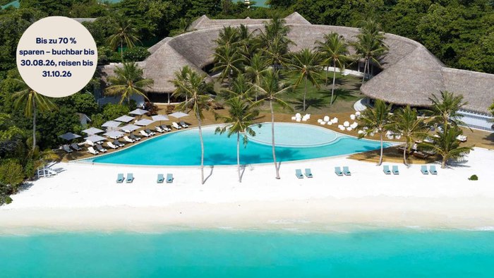 Blick auf den Infinity-Pool und ein Gebäude des Ifuru Island Maldives, umgeben von tropischer Vegetation und mit Aussicht auf den Indischen Ozean | © Ifuru Island Maldives