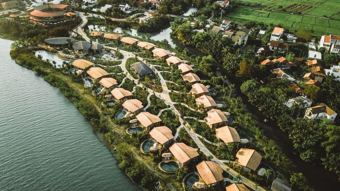 Drohnenaufnahme des Namia River Retreat, eingebettet in üppiges Grün direkt am Thu‑Bon‑Fluss | © Namia River Retreat