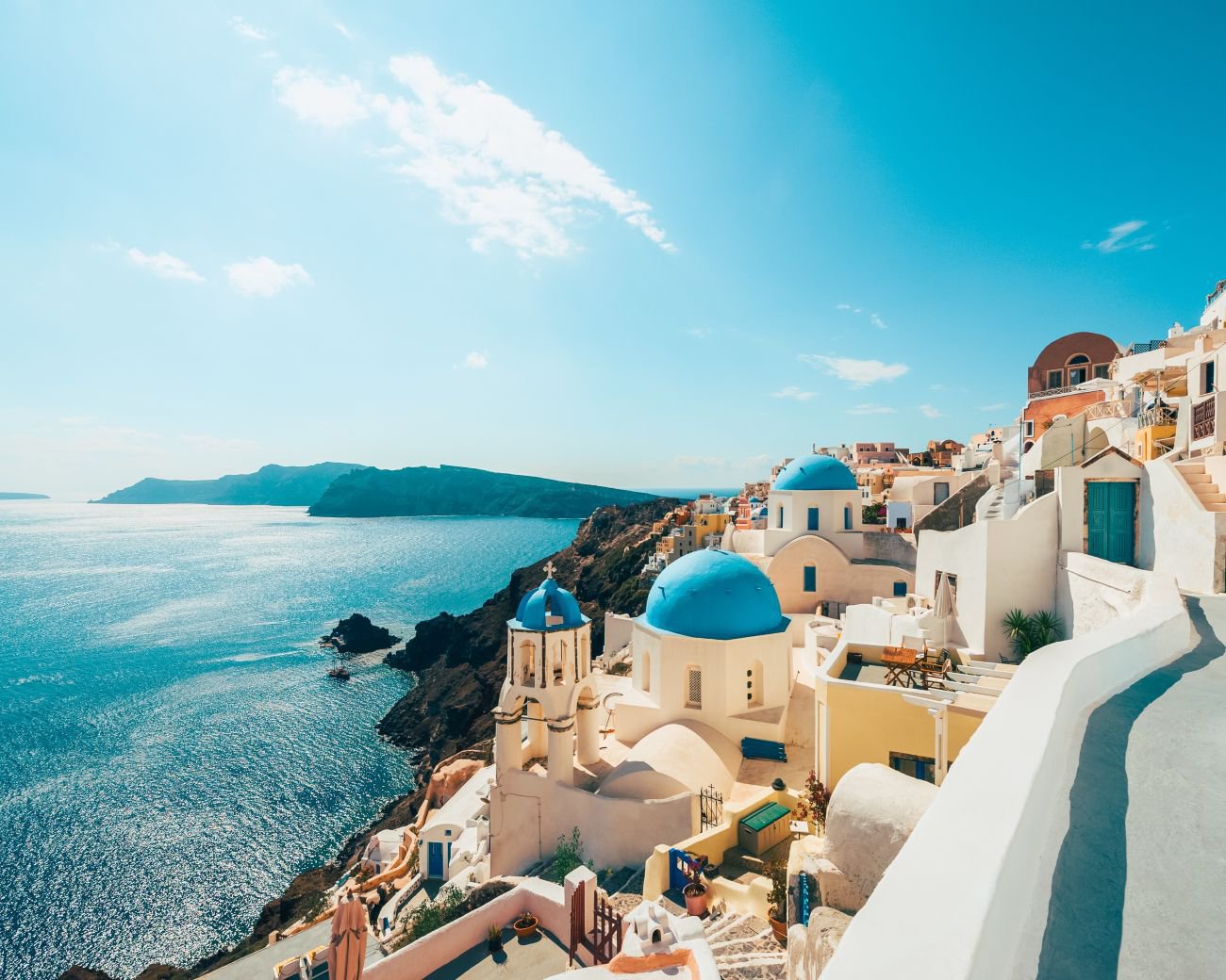 Blick auf Oia auf Santorini, Griechenland mit weiß getünchten Häusern, charakteristischen Kuppeln und der tiefblauen Ägäis | © Getty Images