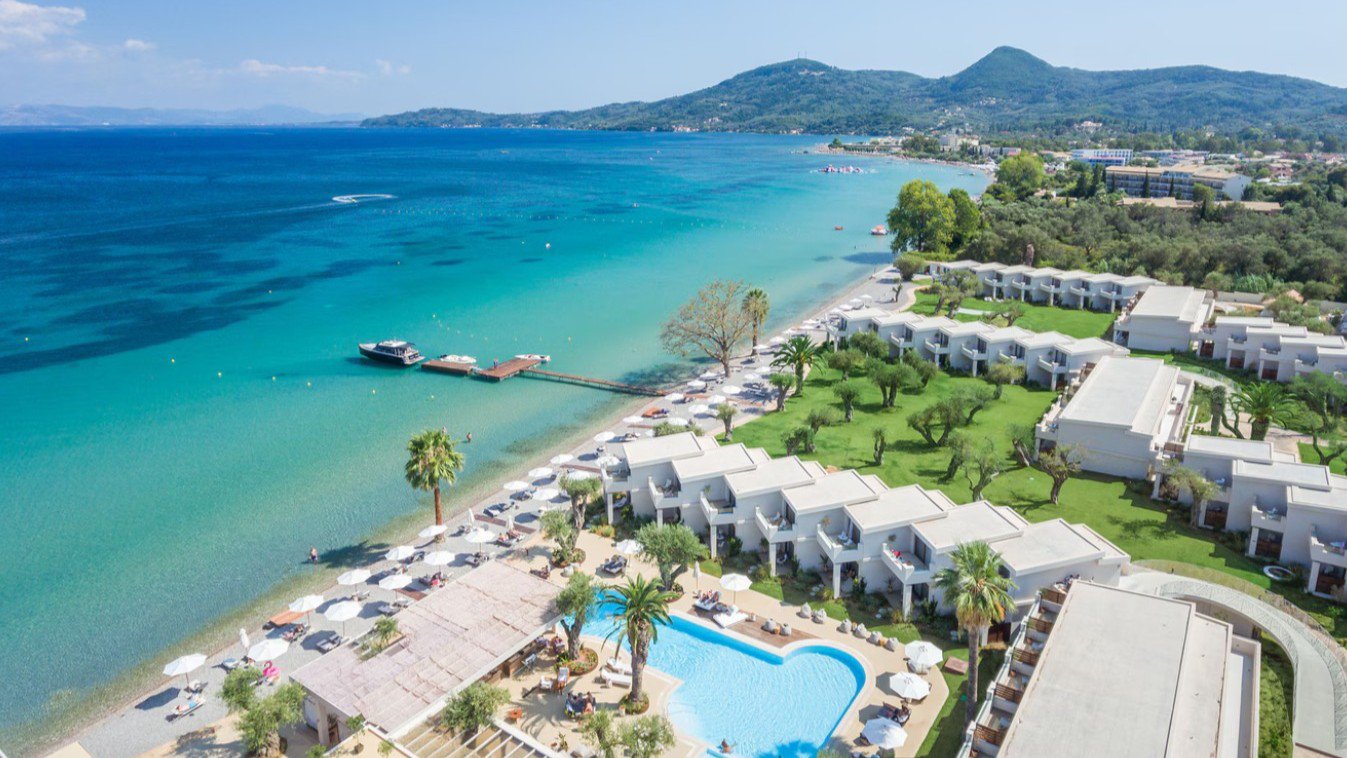 Panoramablick auf das Domes Miramare, a Luxury Collection Resort, Corfu mit Strandbereich und Blick auf das Ionische Meer | © 1996 – 2026 Marriott International